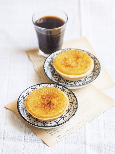Two Portuguese orange tarts and black coffee — Stock Photo
