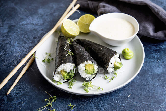 Temaki sushi with avocado and wasabi on plate — Stock Photo