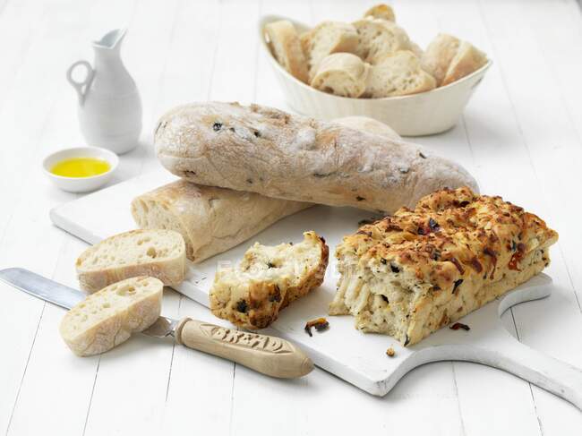 Différents types de pain sur une planche à découper — Photo de stock