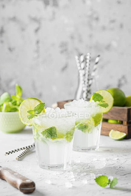 Mojito cocktails aux feuilles de menthe et tranches de citron vert — Photo de stock