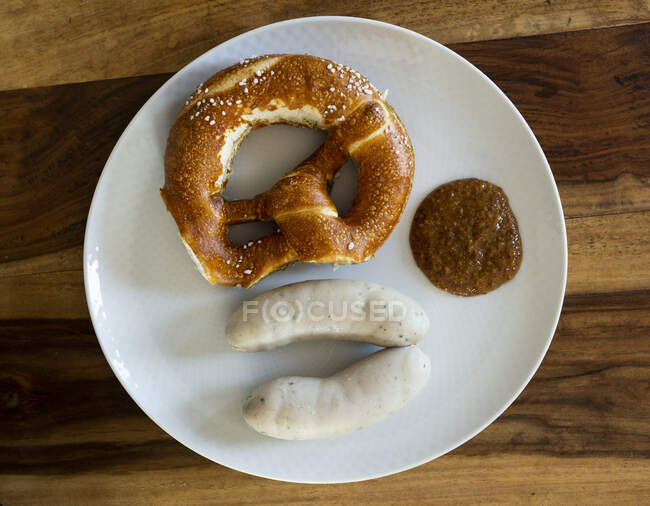 Salchichas blancas con mostaza dulce y un pretzel - foto de stock