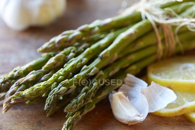 Asparagi verdi, aglio e limoni — Foto stock