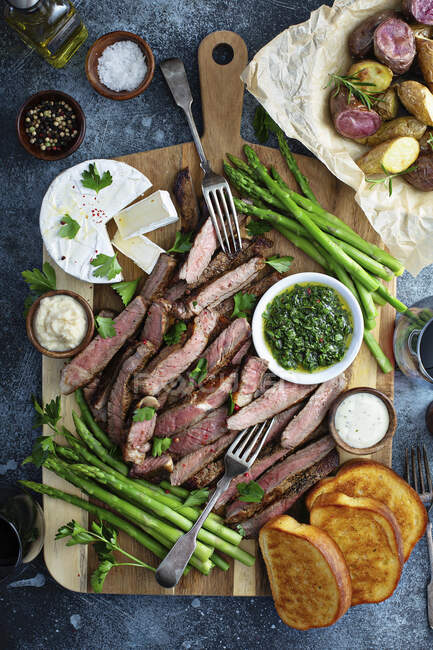 Steak and asparagus platter with potatoes and toast — Stock Photo
