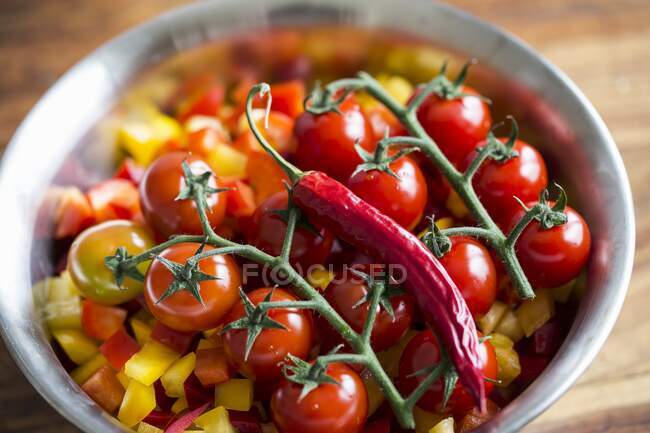 Tomatoes and chillies on chopped peppers — Stock Photo