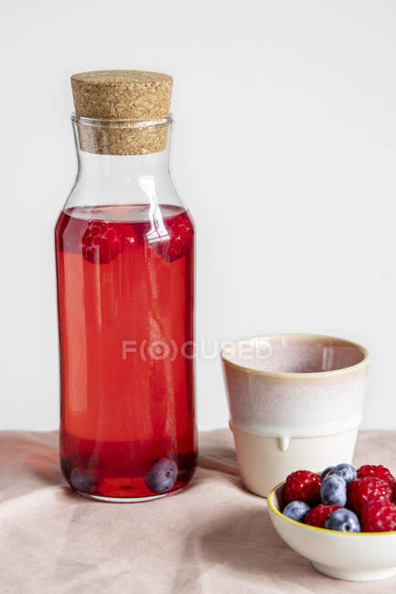 Bevanda estiva con bacche in una bottiglia di vetro — Foto stock