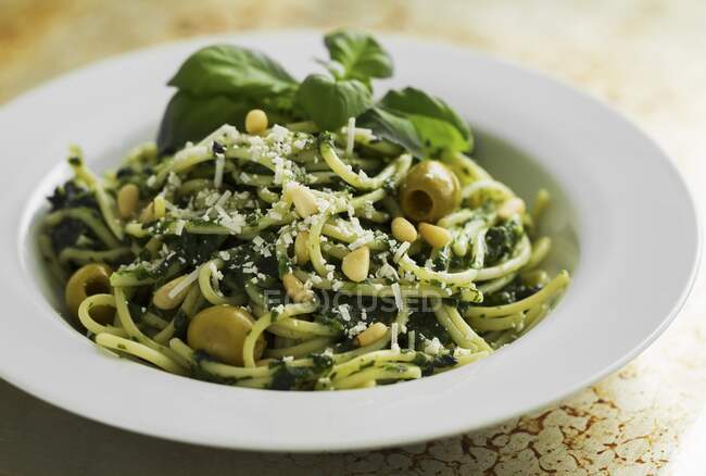 Espaguete com pesto de espinafre e azeitonas verdes — Fotografia de Stock