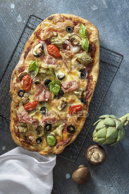 Pizza Capricciosa con alcachofas, jamón y champiñones - foto de stock