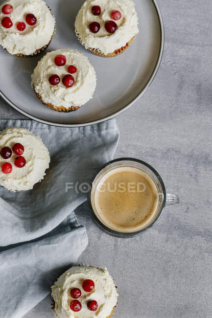 Cupcakes wit classic cream-cheese frosting with cranberries and coffee — Stock Photo