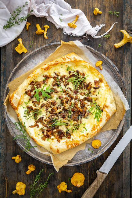 Chanterelle tart with Gruyere and thyme in rustic setting — Stock Photo