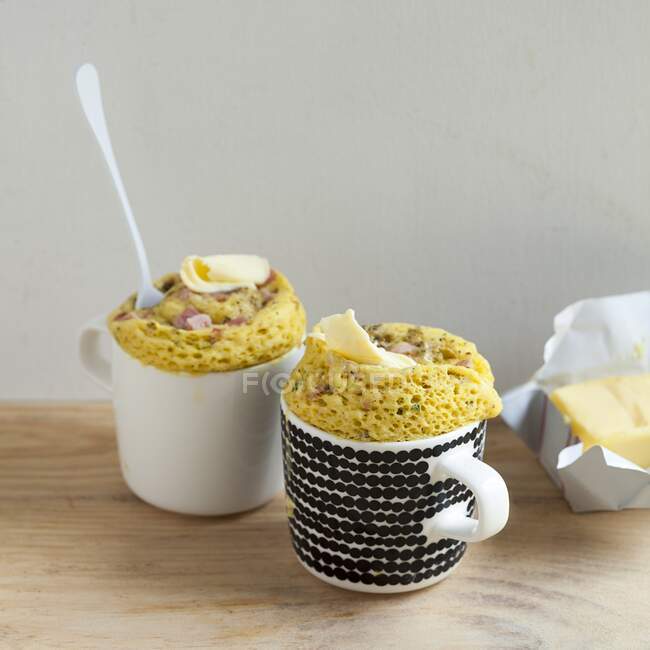Savoury mug cakes with diced ham and a dab of butter on the top — Stock Photo