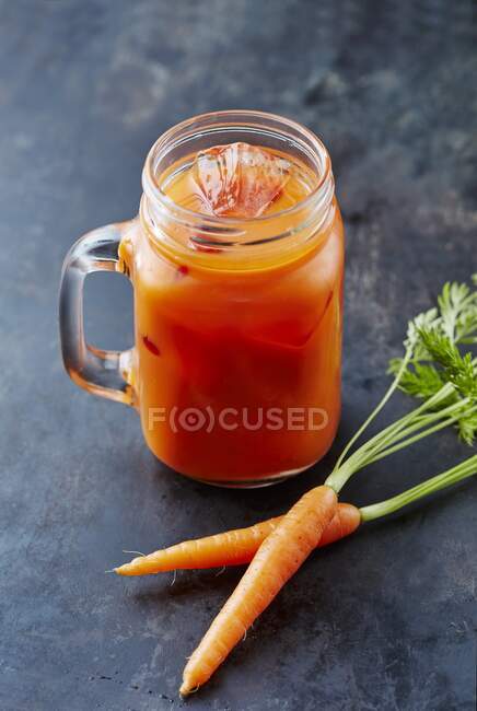 Succo di carota con cubetti di ghiaccio — Foto stock