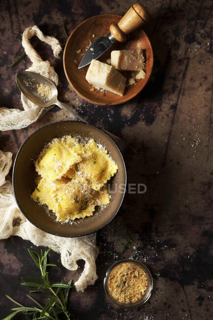 Ravioli in bowl with parmesan cheese and breadcrumbs — Stock Photo