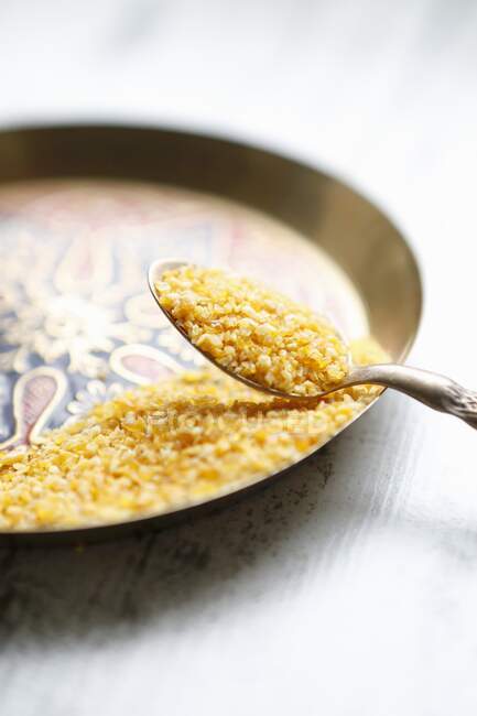Couscous on a spoon and an oriental plate — Stock Photo