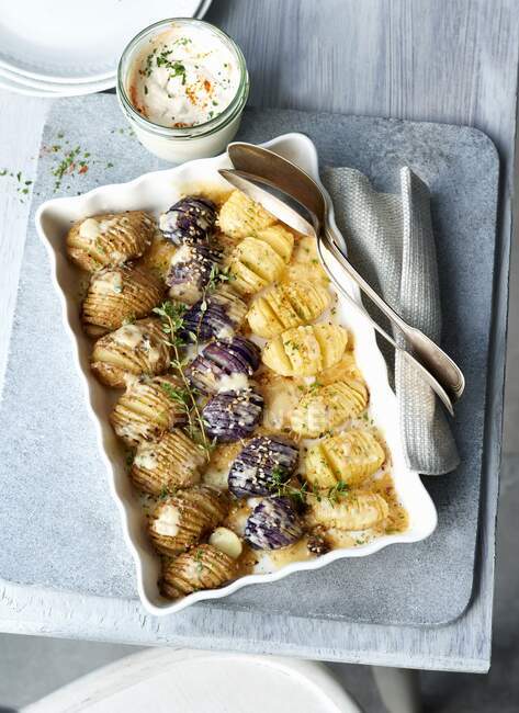 Three kinds of potatoes baked with garlic dip in jar — Stock Photo