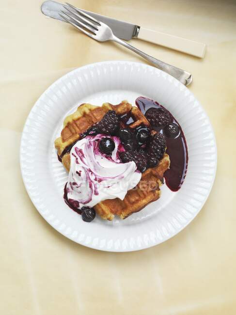 Waffle with yoghurt and baked berries on plate — Stock Photo