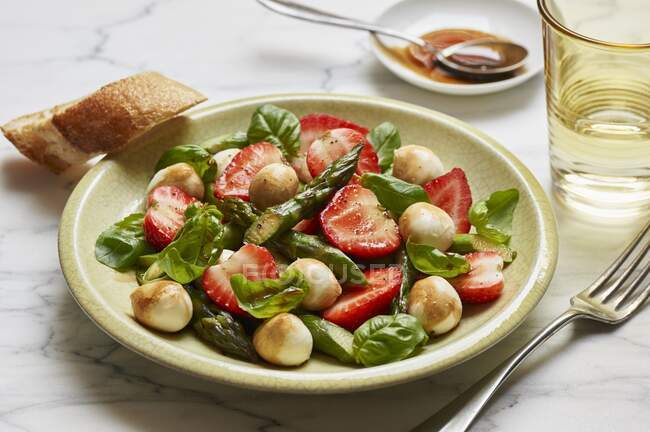 Salada com espargos verdes, morangos, mini bolas de mussarela e manjericão fresco — Fotografia de Stock