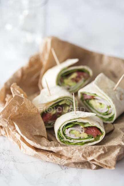 Tortilla rolls with lettuce, spinach, ham, avocado and tomatoes — Stock Photo