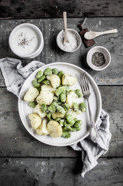 Potato and broad beans salad served with yoghurt — Stock Photo