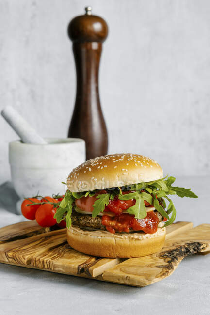 Spicy beef burger with arugula and white sesame bun — Stock Photo
