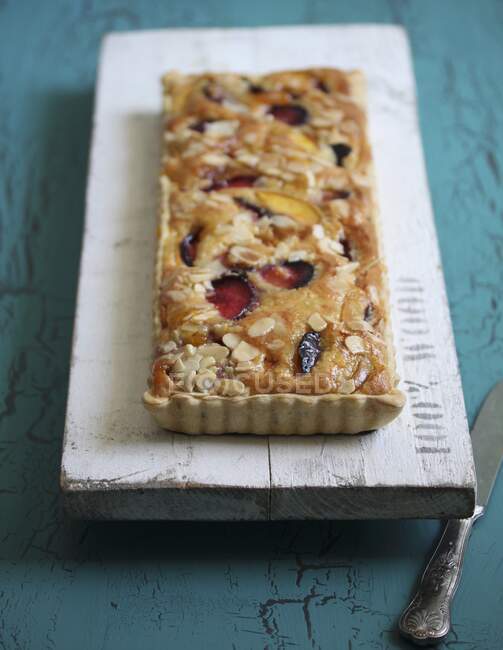 Plum cake with flaked almonds — Stock Photo