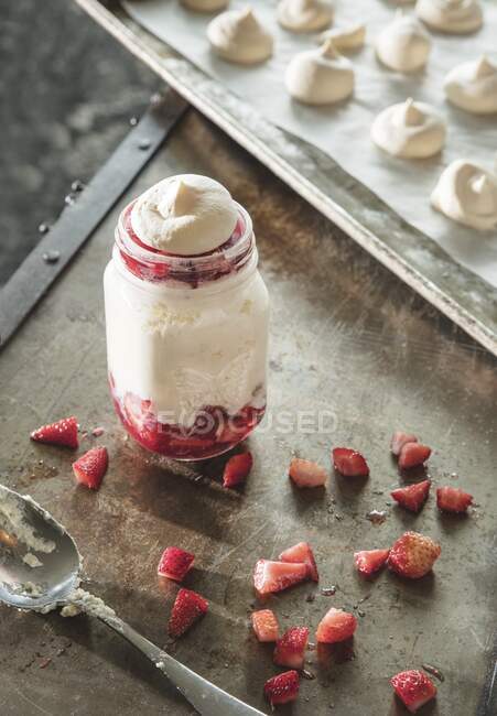Postre de helado servido con fresas y merengue en frasco - foto de stock