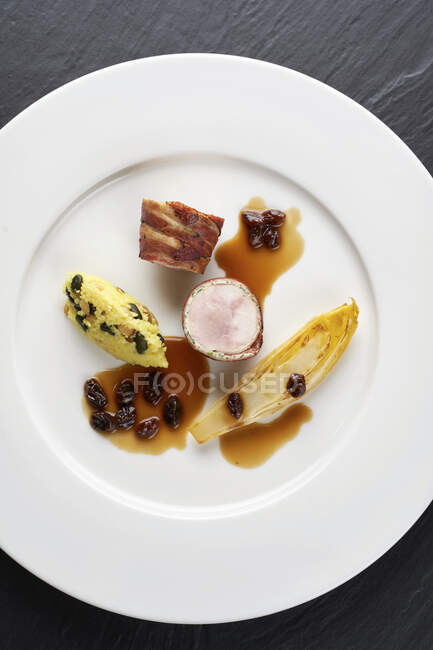 Pheasant breast wrapped in ham with raisins, chicory and polenta — Stock Photo