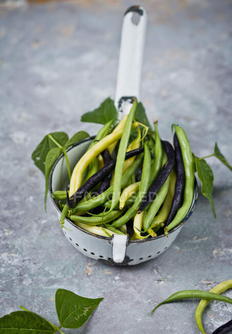 Fresh green and yellow beans in a vintage colander — Stock Photo