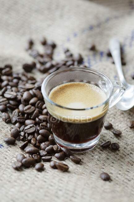 Espresso coffee with coffee beans and a teaspoon — Stock Photo
