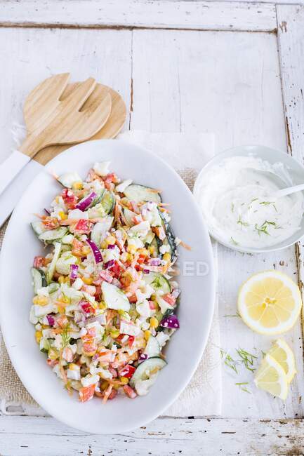 Colourful vegetable salad with yoghurt and dill dressing and lemon — Stock Photo