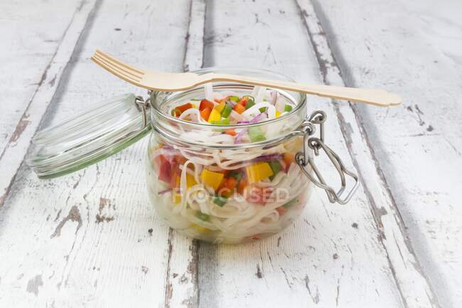 Стеклянный салат из лапши с желтым и красным перцем, луком и красным луком — стоковое фото