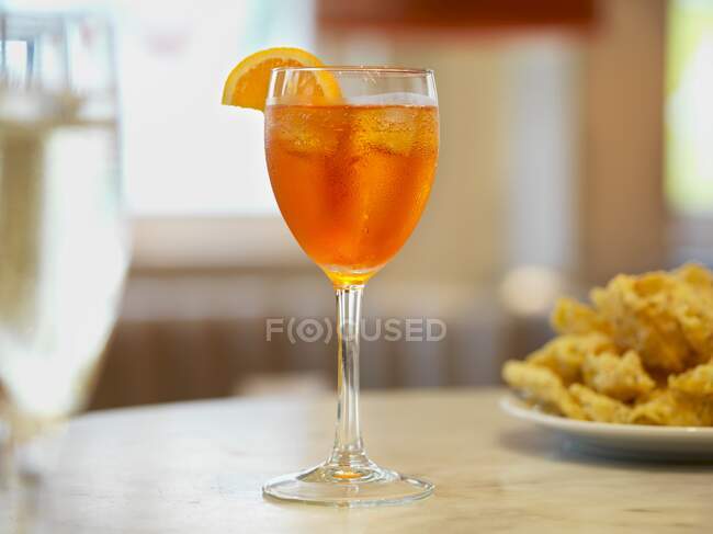 Aperol spritz with orange slice at restaurant table — Stock Photo