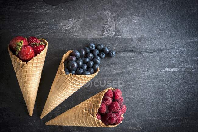 Различные ягоды в рожках мороженого — стоковое фото