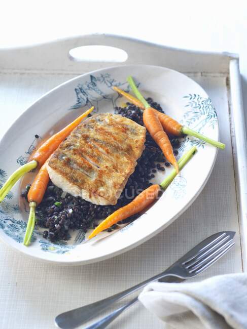 A zander fillet with beluga lentils and carrots — Stock Photo