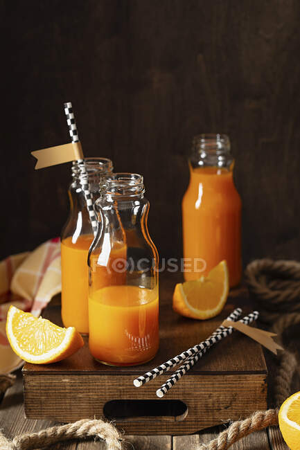 Sumo vitamínico fresco em pequenos frascos (sumo de laranja e cenoura) — Fotografia de Stock