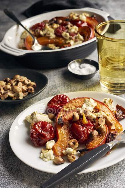 Roasted pumpkin with cherry tomatoes, sheep's cheese and hazelnuts — Stock Photo