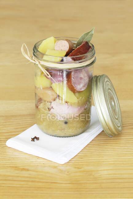 Sauerkraut with sausage and potatoes in a glass jar — Stock Photo