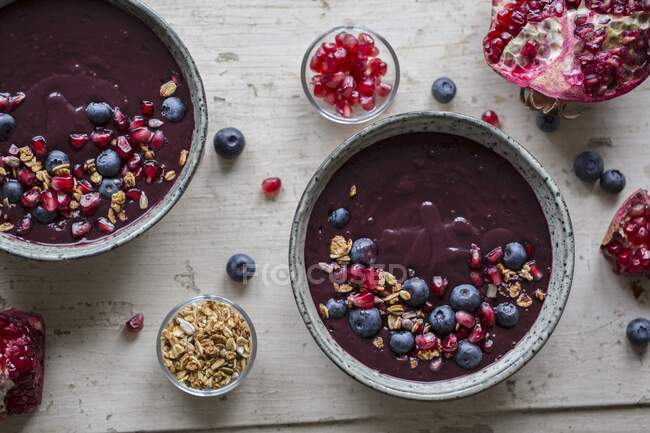 A smoothie bowl with pomegranate seeds, blueberries and granola — Stock Photo