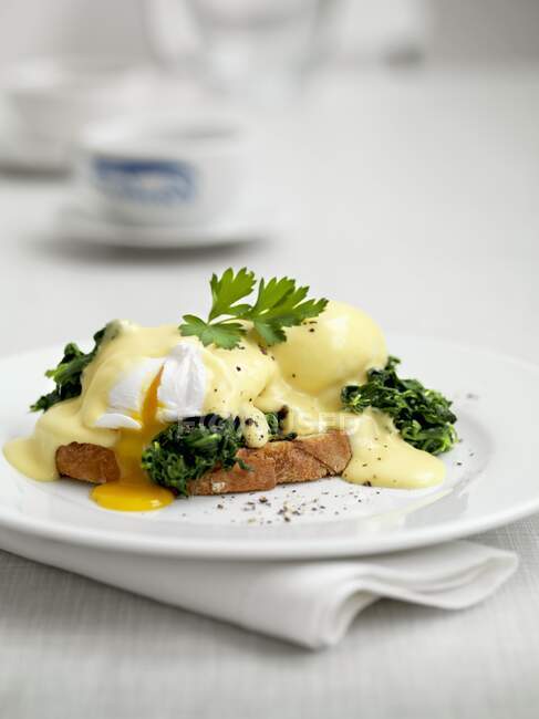 Eggs Benedict on toast with herbs and sauce — Stock Photo