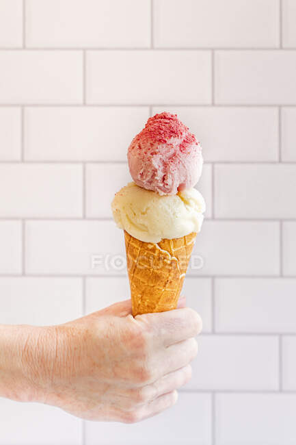 Woman with ice cream cone topped with strawberry fruit powder — Stock Photo