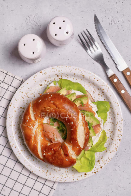 Bagel with cream cheese, lettuce, smoked salmon and avocado — Stock Photo