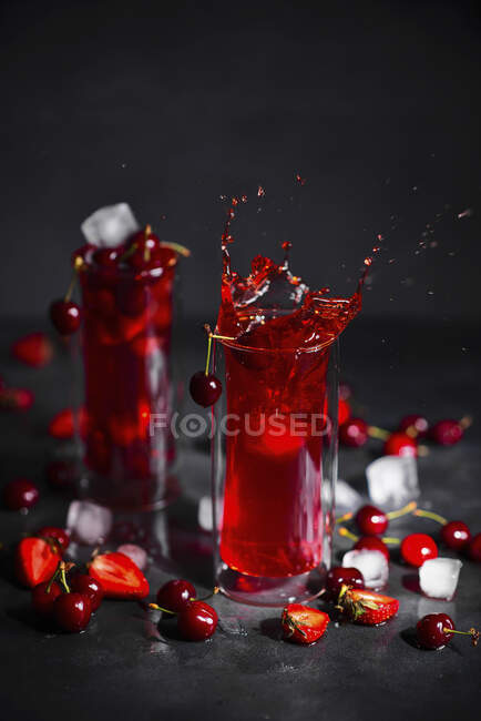 Strawberry, rhubarb and cherry drink with ice — Stock Photo