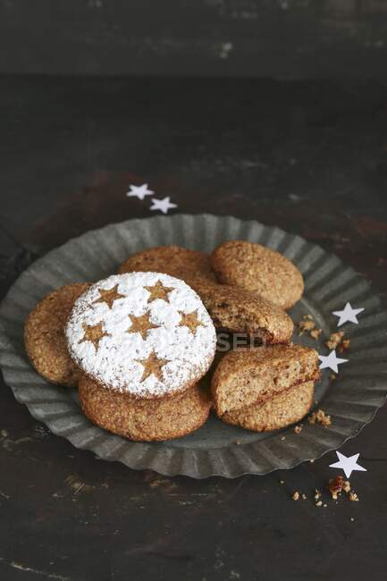Pan de jengibre casero sin gluten decorado con estrellas y azúcar en polvo en un plato de hojalata - foto de stock