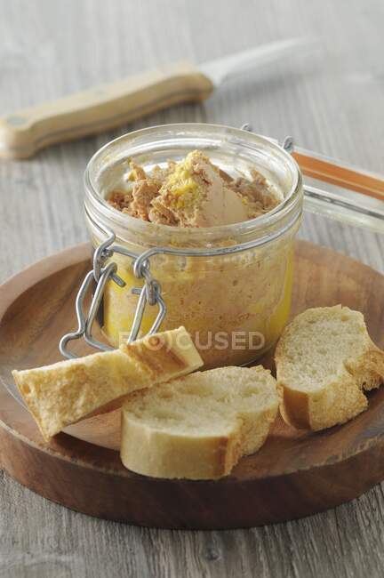 Foie gras in a glass jar with baguette slices — Stock Photo