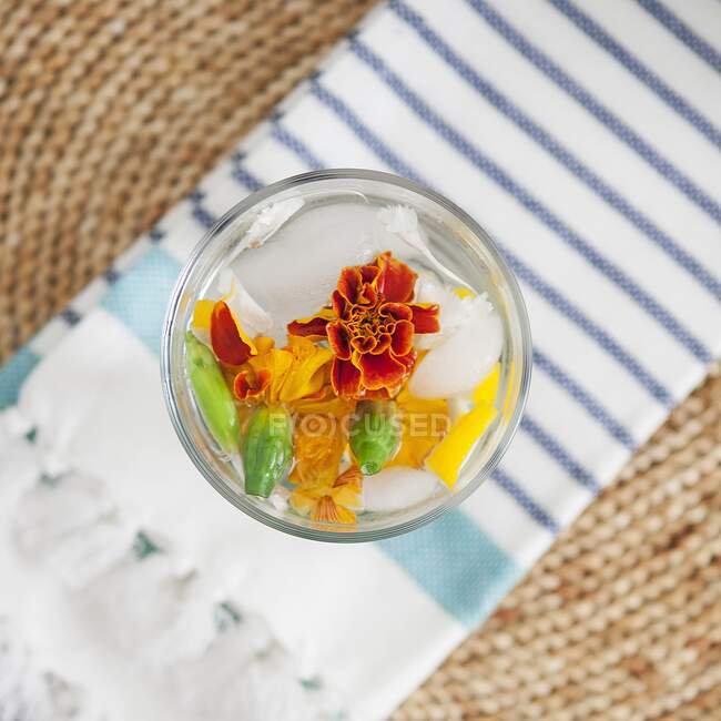 Mineral water in a glass infused with melon and edible flowers (top view) — Stock Photo