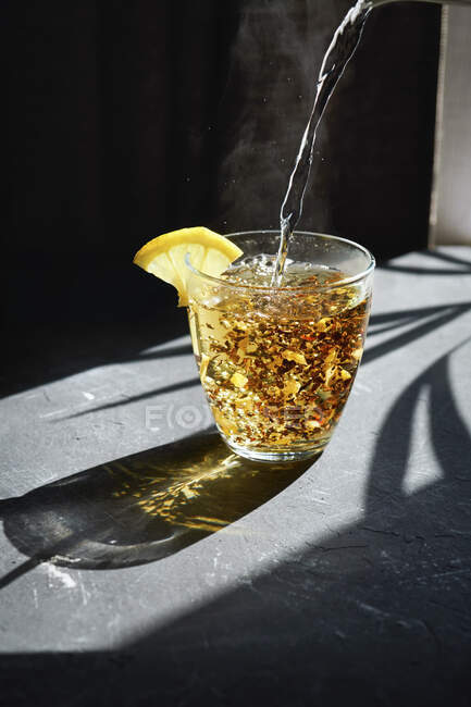 Agua hirviendo que se vierte sobre té de frutas - foto de stock