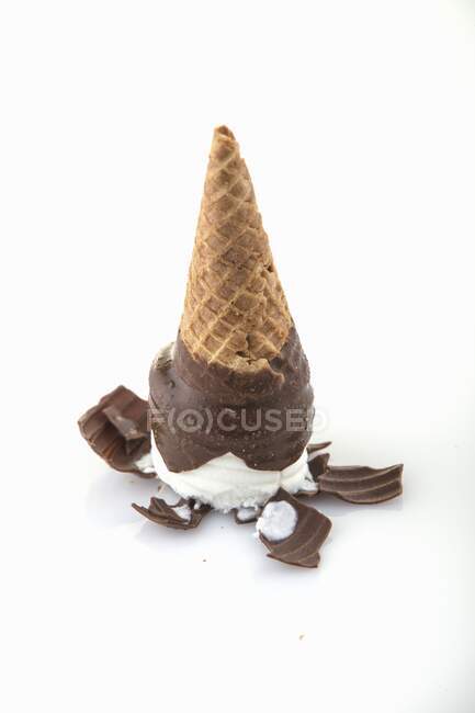 Um cone de sorvete coberto de chocolate virado de cabeça para baixo — Fotografia de Stock