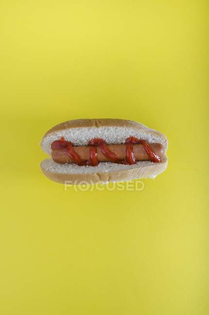 Un hot dog sur fond jaune — Photo de stock