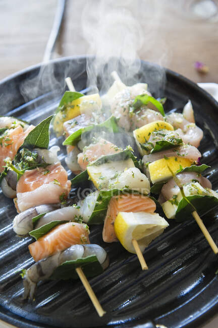 Espetos de peixe fumegante na panela de grelha — Fotografia de Stock