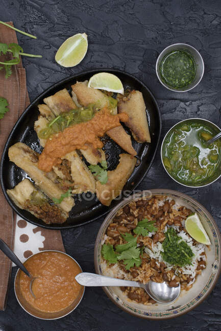 Fried vegan tamales in cast iron serving plate along with ranchero sauce and chili cilantrio salsa — Stock Photo