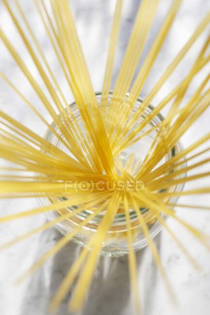 Неприготовленные спагетти в стеклянной банке — стоковое фото